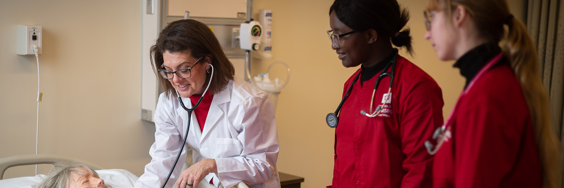 Faculty nurse demonstrating skill to students