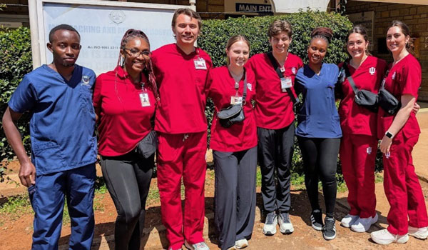 A group of IU School of Nursing students and partners pose for a photo outside a healthcare facility in Kenya.