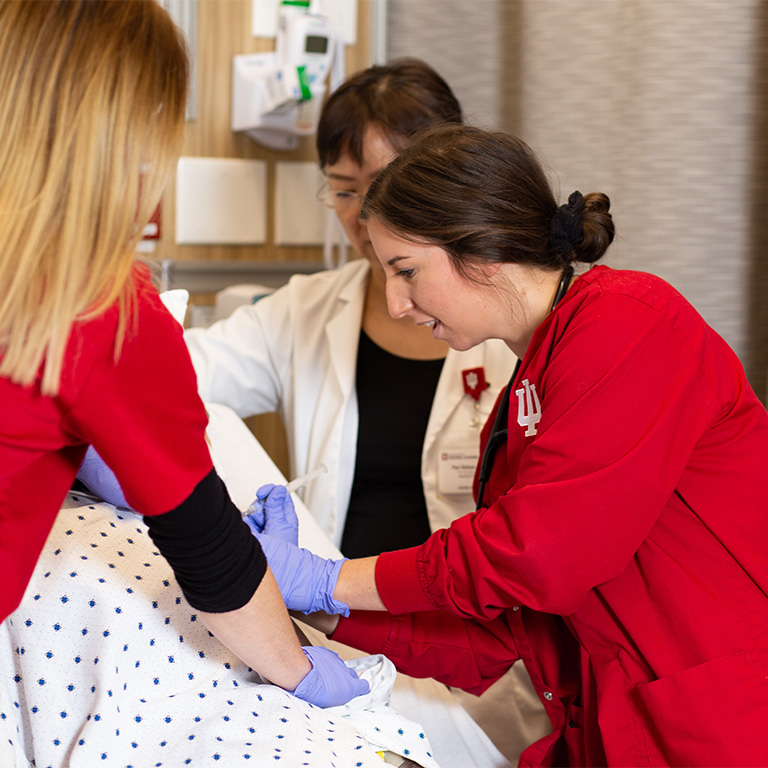 Nursing students at the Simulation and Skills Center being guided by instructor