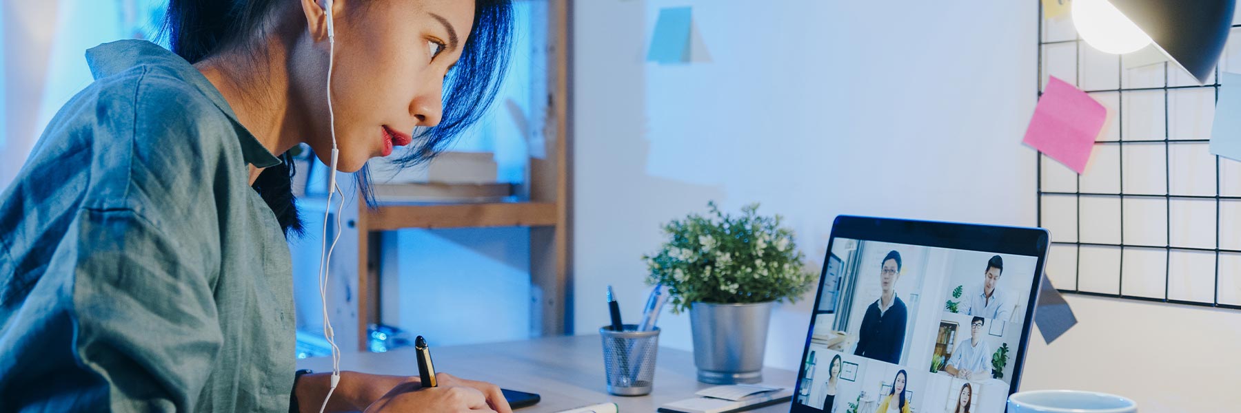 Student taking notes during an online conference
