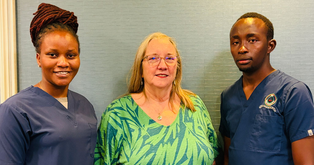 Moi University students Nancy Muthoni Nyaga and Dancan Kirabi pose for a photo with IU School of Nursing's Dr. Barbara deRose