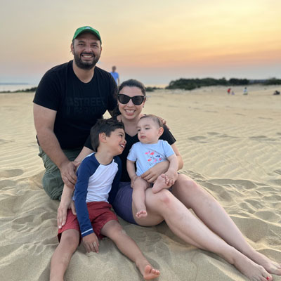 Tatiana Laitano Rodriguez, her husband and two children pose for a photo on a beach
