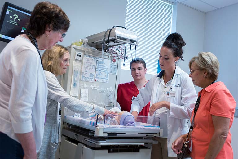 A group examines the baby manikin