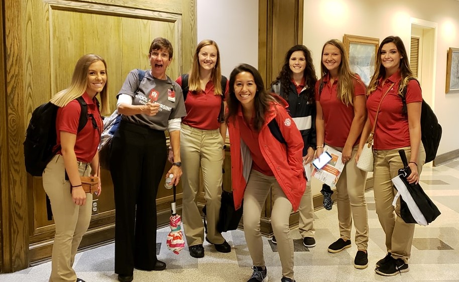 Group of students and staff smiling at the camera