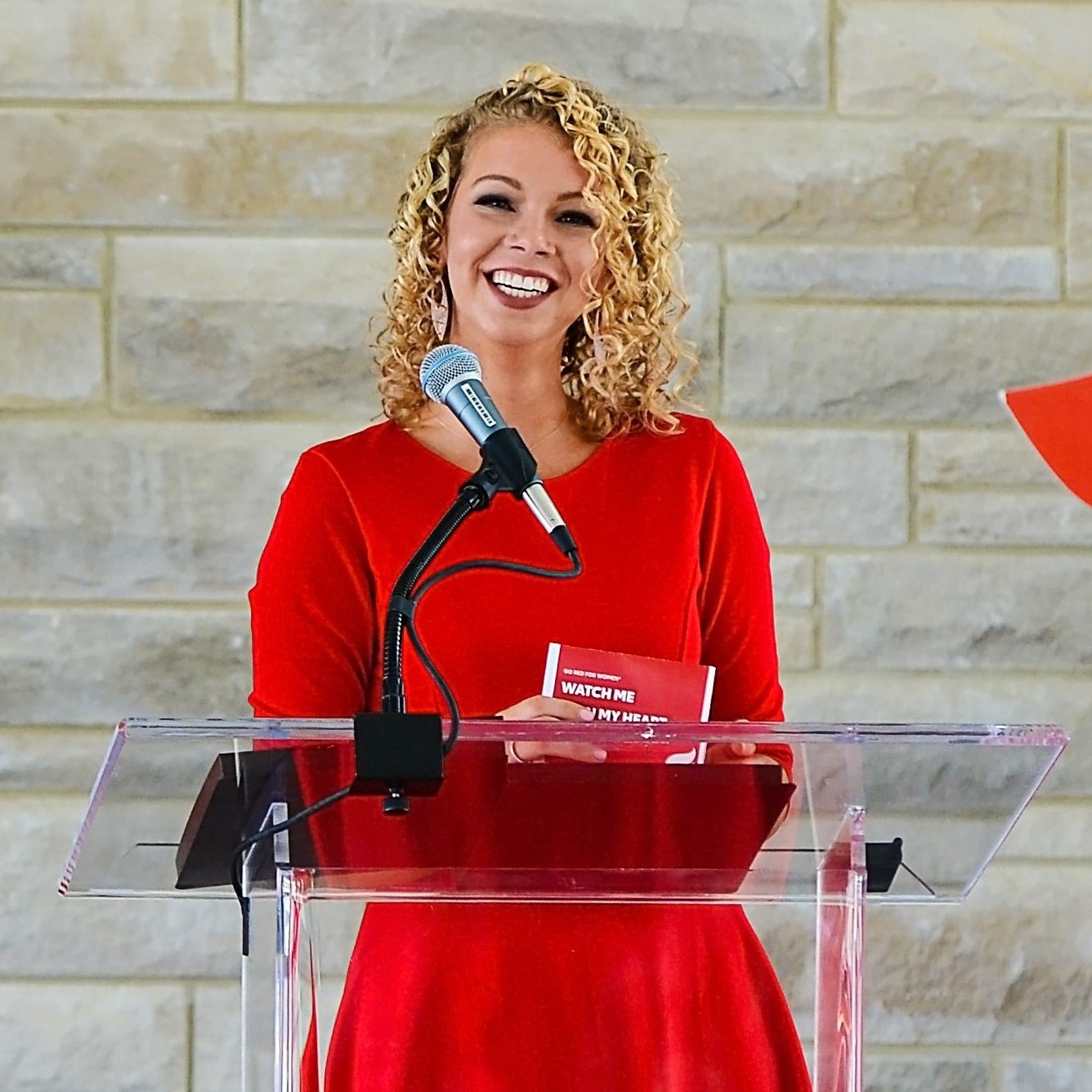 Woman in red at podium